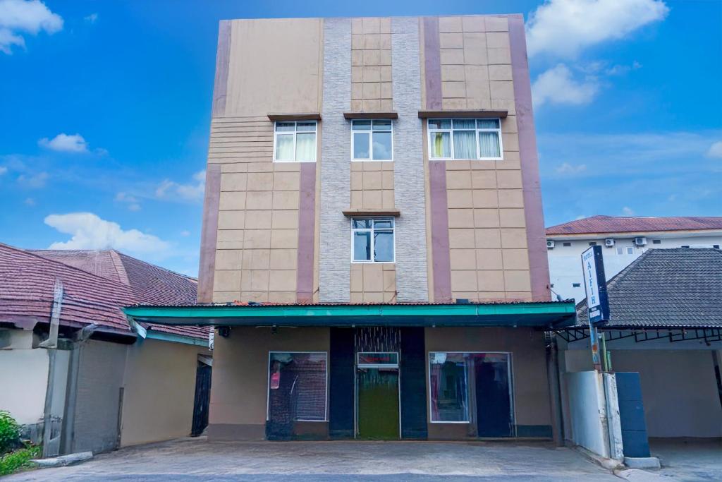 a tall brick building with a green door at Collection O R.Sukamto Near Palembang Trade Center Mall in Palembang