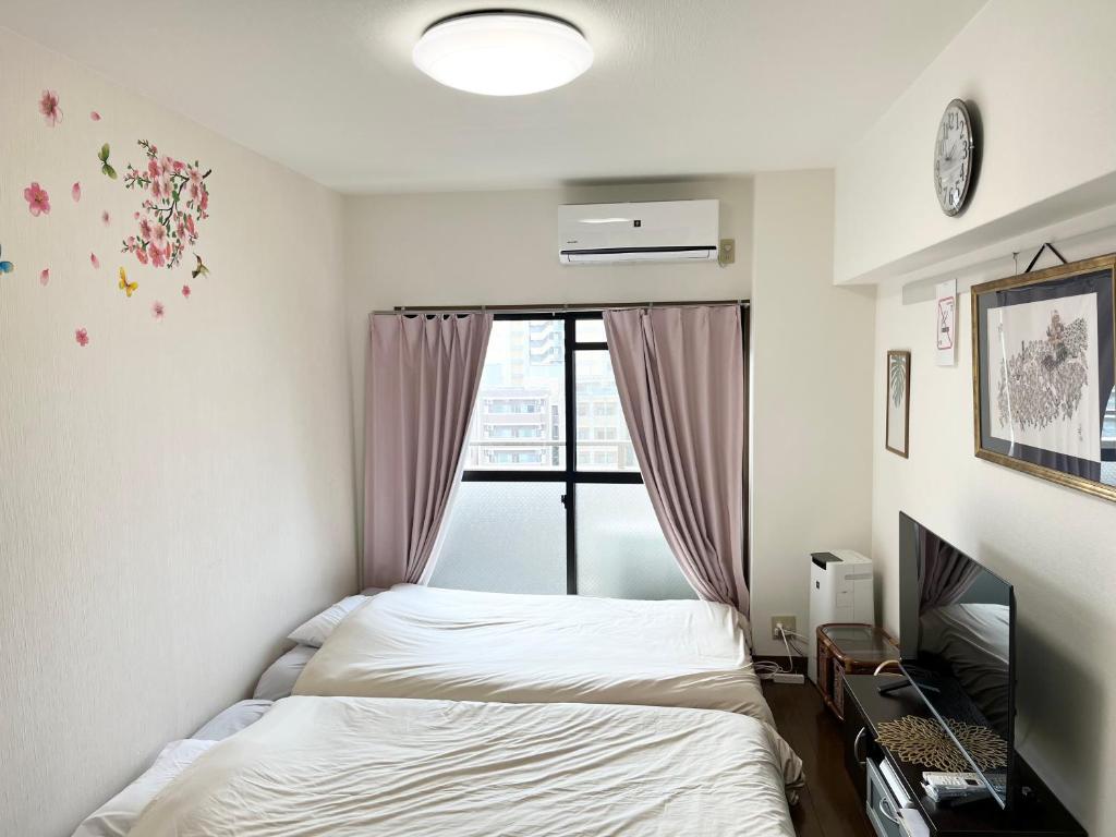 une chambre avec deux lits et une fenêtre dans l'établissement 駅南うちやまビル1, à Fukuoka
