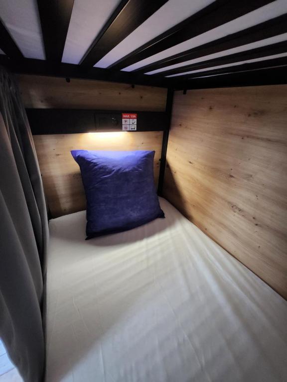 a bed with a blue pillow in a room at Gite Compostella in Saint-Jean-Pied-de-Port