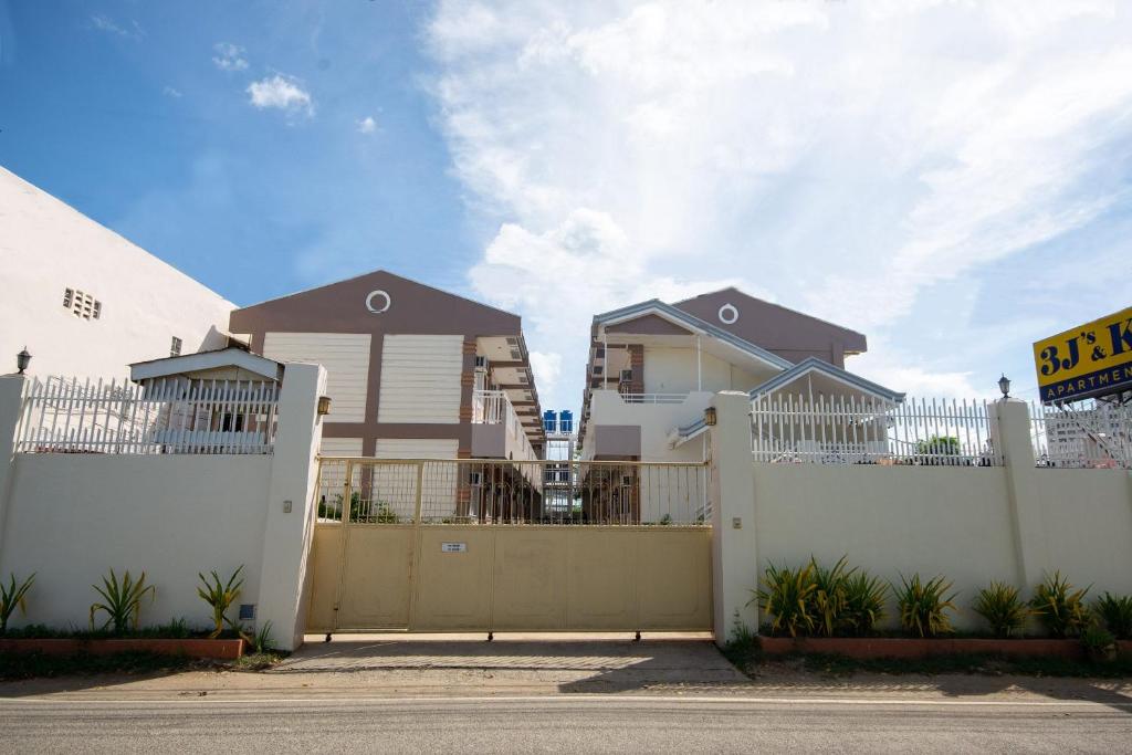 a house with a white fence and a gate at 3j's And K Apartment in Cebu City