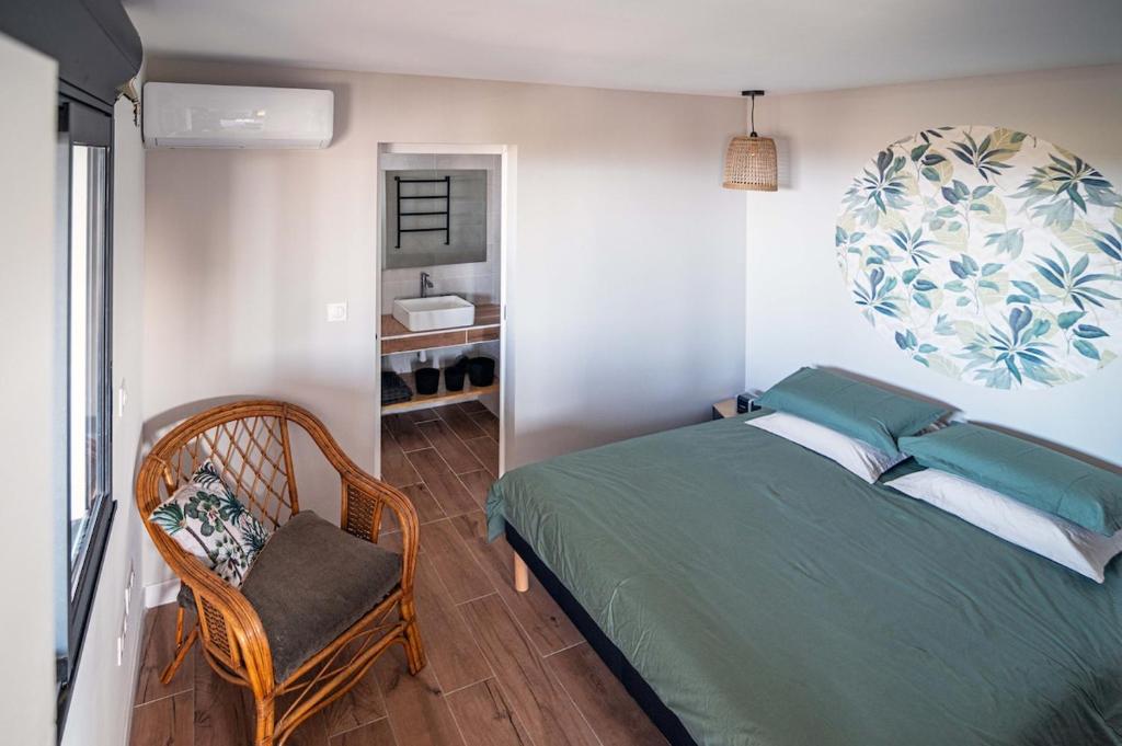 a bedroom with a bed and a chair and a mirror at Sweet Moka in Sainte-Marie