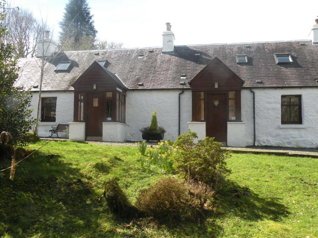 a house with a green yard in front of it at McHugh and Loudon Cottages in Saint Catherines