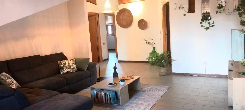 Una sala de estar con un sofá y una mesa de café. en Vacanze in Mansarda, en Oristano