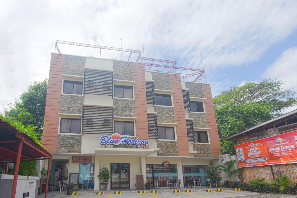 Un edificio con un cartel en el costado. en OYO 567 Blue Horizon Hostel, en Dumaguete