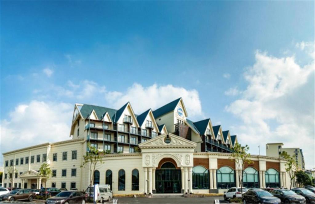 a large building with cars parked in front of it at Blue Palace Hotel in Jiading