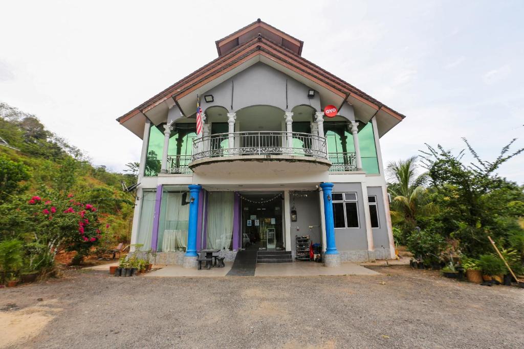 a building with a balcony on top of it at OYO 89933 Nun Hotel in Jeli