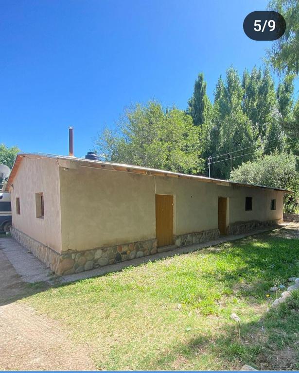 a small building with two doors in a yard at Casa de campo in Uspallata