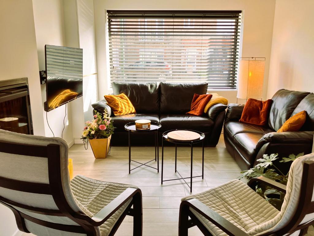 デ・パンネにあるVakantiehuis Zeevonkの革張りのソファとテーブルのあるリビングルーム