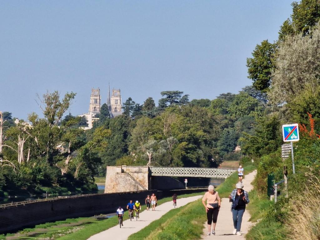 un groupe de personnes marchant sur un chemin dans un parc dans l'établissement Saint-Jean-de-Braye Combleux Une simple petite maison, à Saint-Jean-de-Braye