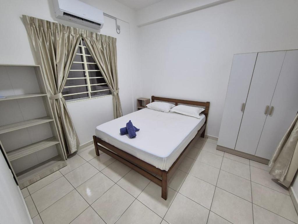 Un dormitorio con una cama blanca y una ventana. en IJM Suria Homestay, en Sandakan