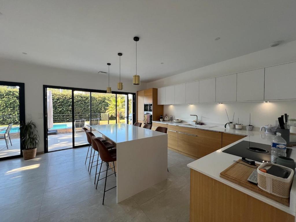 une cuisine avec un grand îlot au milieu dans l'établissement Villa moderne avec piscine chauffée, à Villeneuve-lès-Avignon