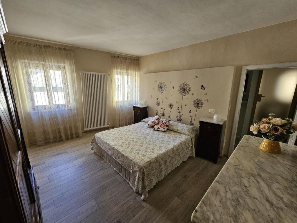 a bedroom with a bed and two windows at Il nido dei Priori in Volterra