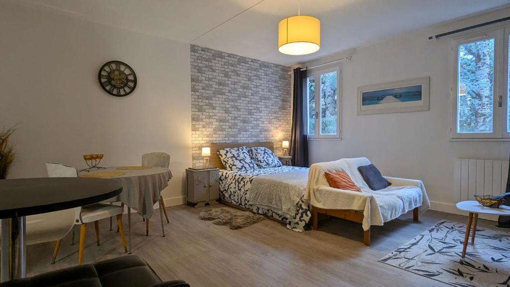 une chambre avec un lit, une table et des chaises dans l'établissement Studio spacieux - Labronie, à Sarlat-la-Canéda