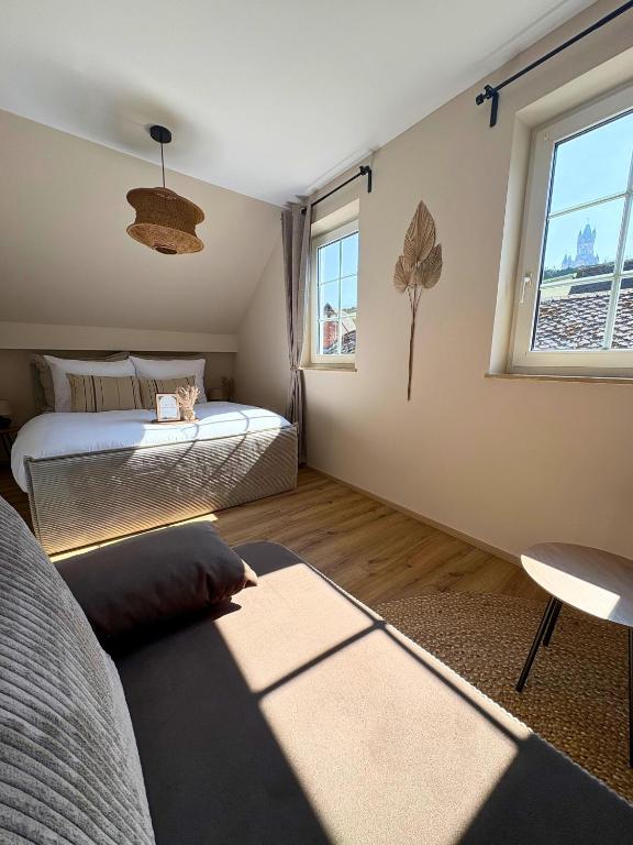 a bedroom with two beds and a couch and a window at Apartment Ikigai in Cochem
