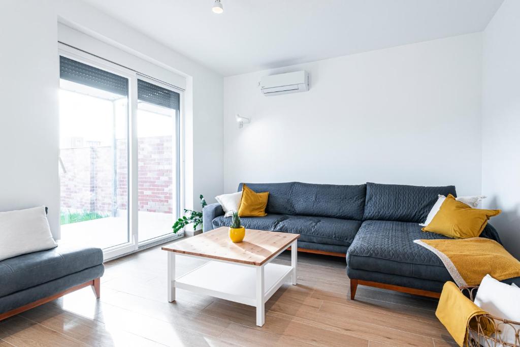 a living room with a blue couch and a table at Novi Sad's Quiet Quarters in Novi Sad