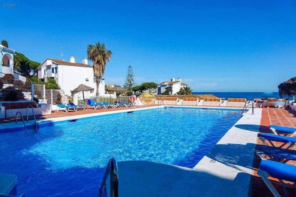 a swimming pool with a view of the ocean at Alhamar Cabopino Living Apartment in Málaga
