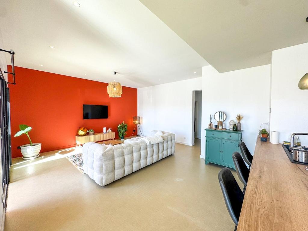 - un salon avec un canapé blanc et un mur orange dans l'établissement Villa neuve moderne, à Saint-Quentin-la-Poterie