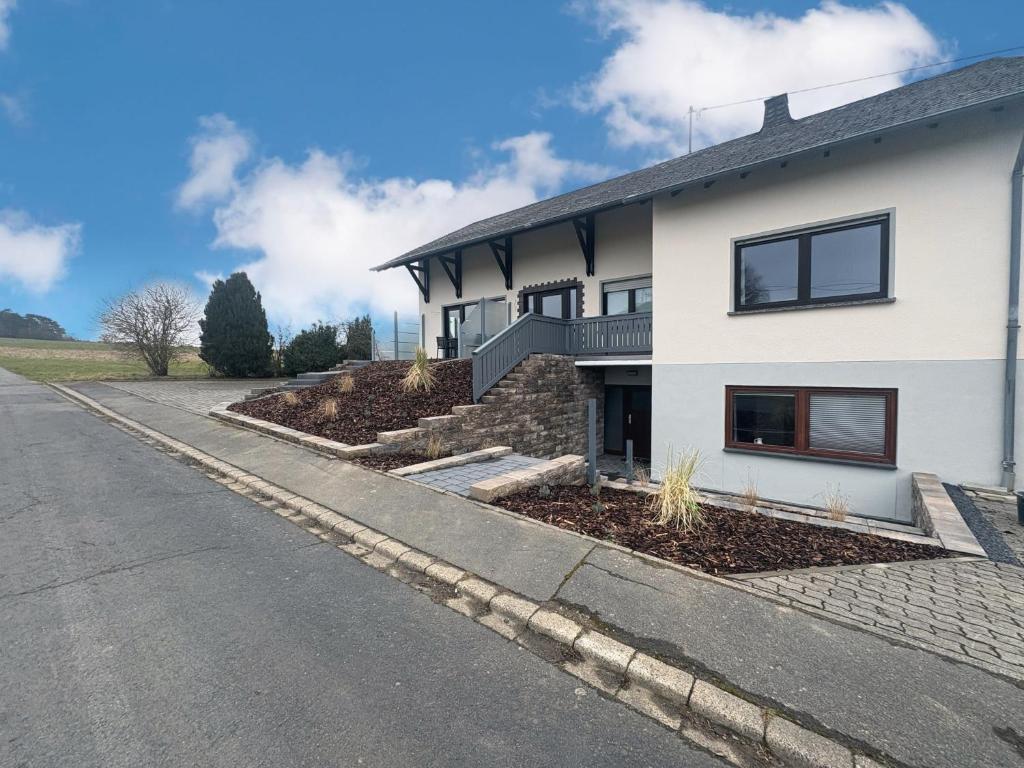 een wit huis aan de kant van een weg bij Maxi-Apartment Bodanum - mit eigener Terrasse - naturnahe Ortsrandlage - VDSL - 10 min zum Nürburgring in Bodenbach