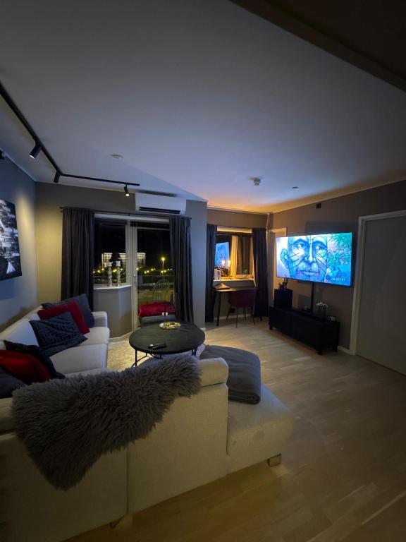 a living room with a couch and a flat screen tv at 3-room downtown apartment in Trondheim