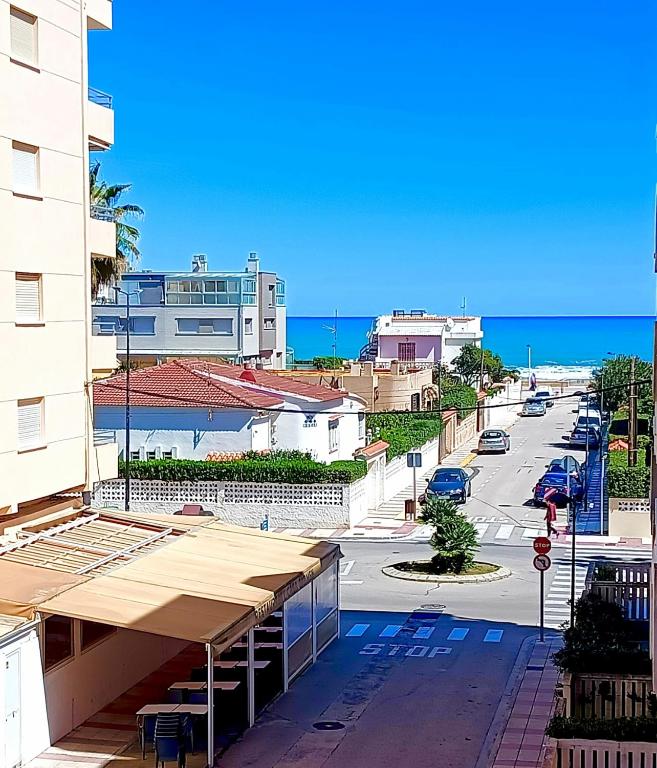 a view of a street with a building and the ocean at Playa Daimus 100 m del Mar Piscina Parking in Daimuz