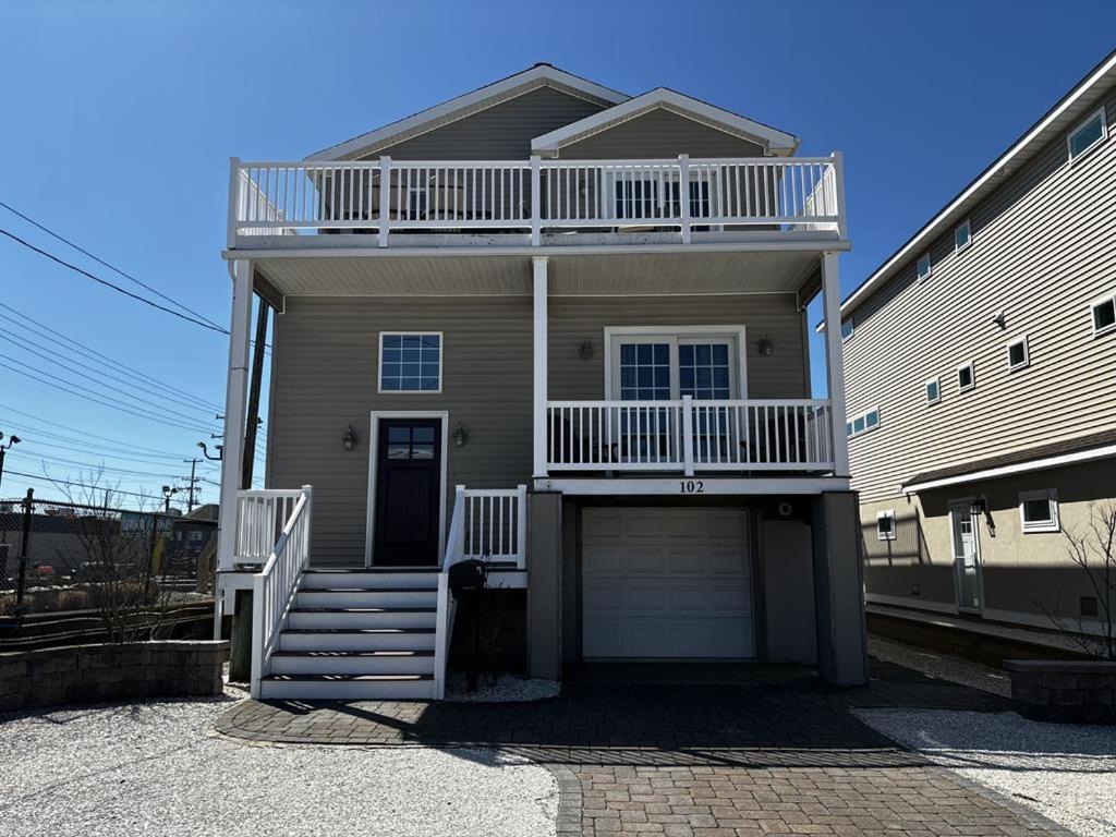 a house with a balcony and a garage at Roof-Top Deck With Ocean & Bay Views Single Family Beach Badges Private Yard Ping Pong And Pool Table Wifi 1 Block From Ocean 15 Blocks To Bay in Ship Bottom