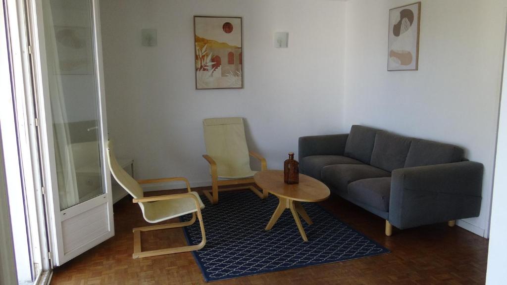un salon avec un canapé, des chaises et une table dans l'établissement Appartement T3-4 meublé Toulouse Soupetard, à Toulouse