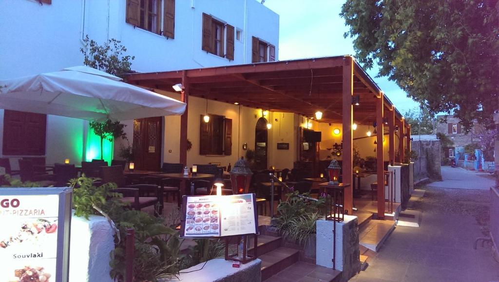 a restaurant with tables and chairs and an umbrella at Mango Rooms in Rhodes Town