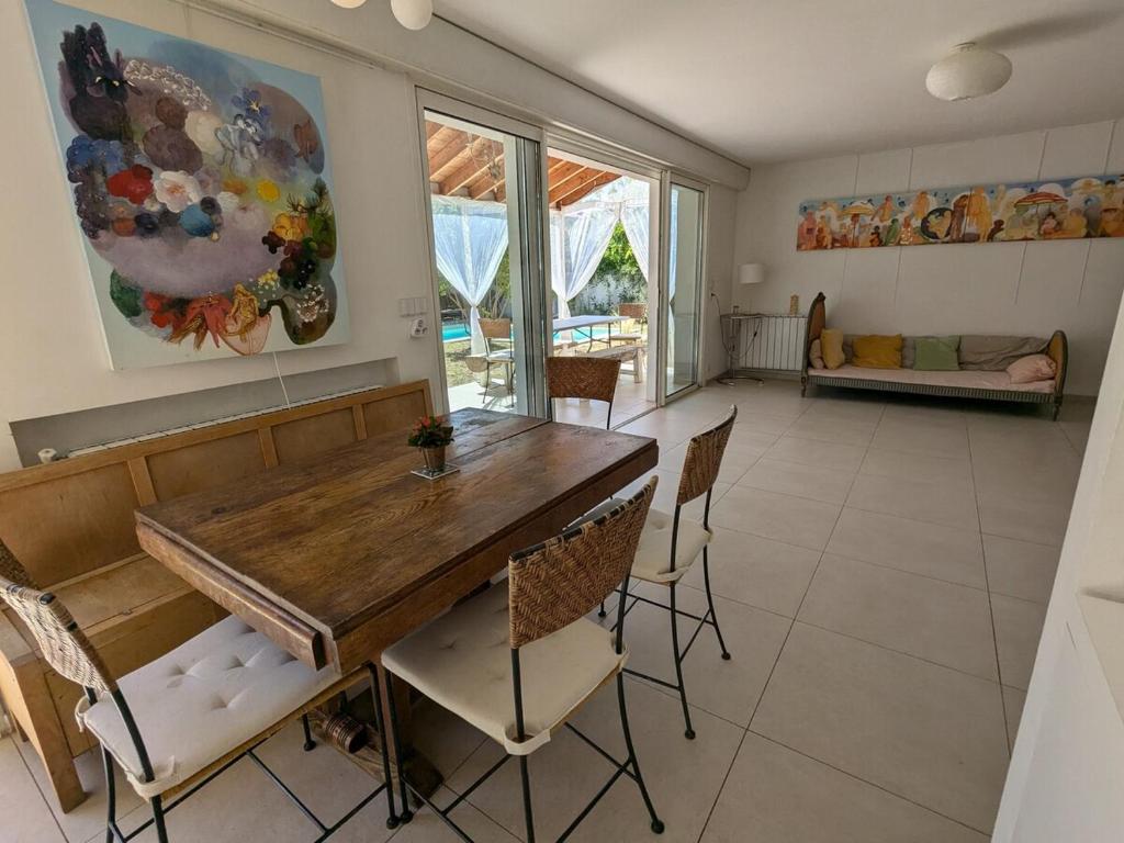 une salle à manger avec une table et des chaises en bois dans l'établissement Villa avec piscine proche Plages, à Pérols