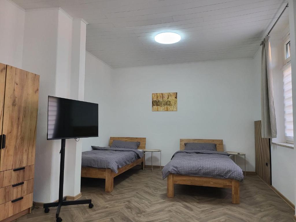a room with two beds and a flat screen tv at Sehr gut gelegene Wohnung im Herzen Hannovers in Hannover
