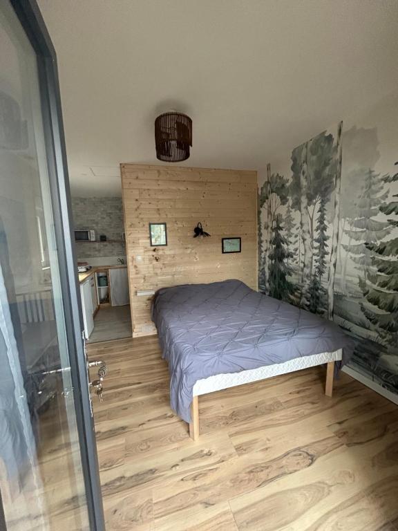 a bedroom with a bed and a glass door at Maison Vaniméou in Pouzauges