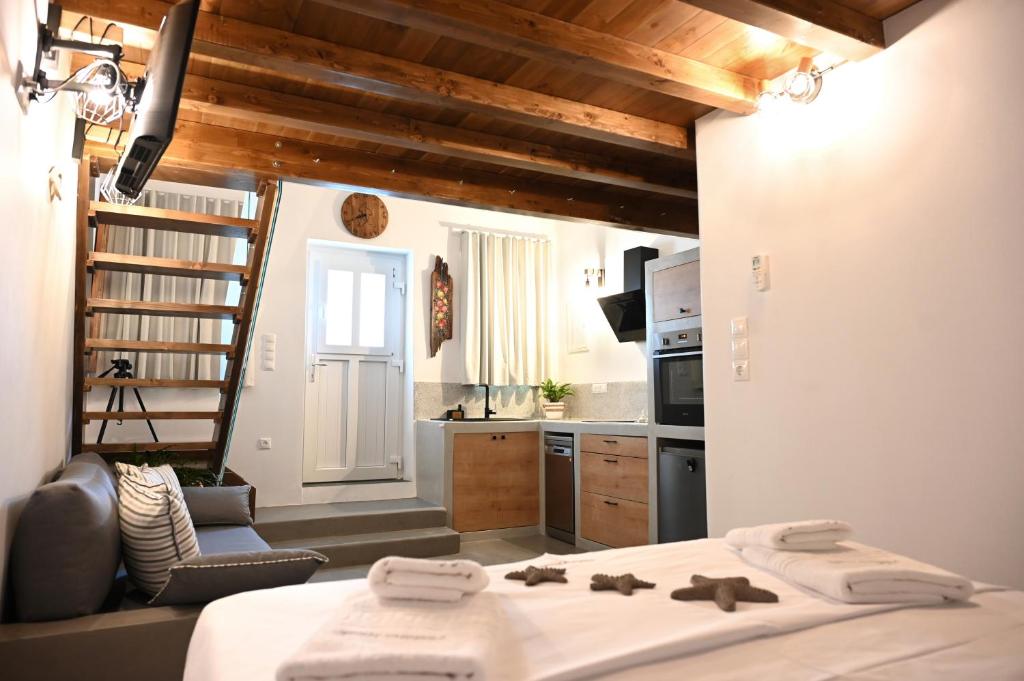 a bedroom with a bed and a kitchen with a ladder at Plakares Studio 1 in Kithnos