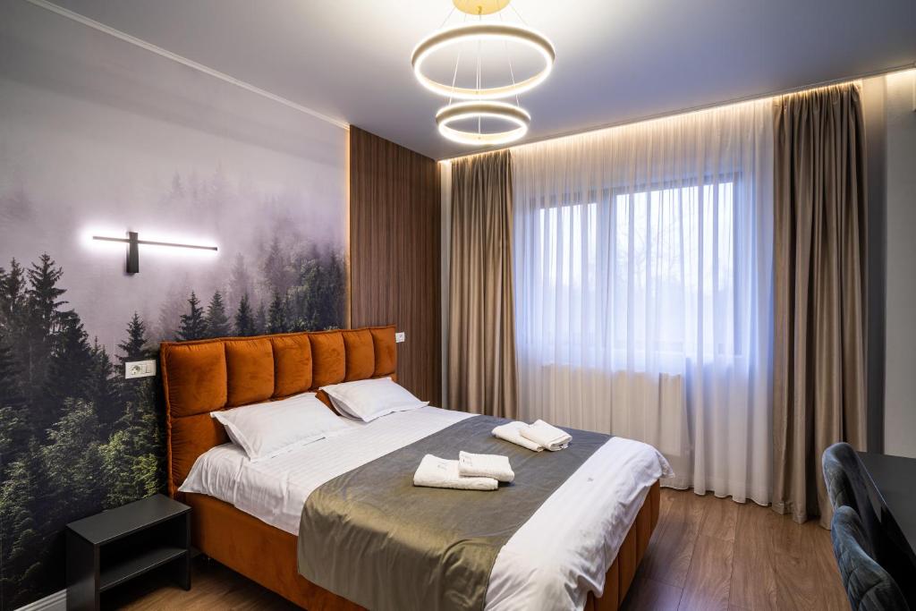 a bedroom with a bed with two towels on it at Transalpina Retreat in Novaci