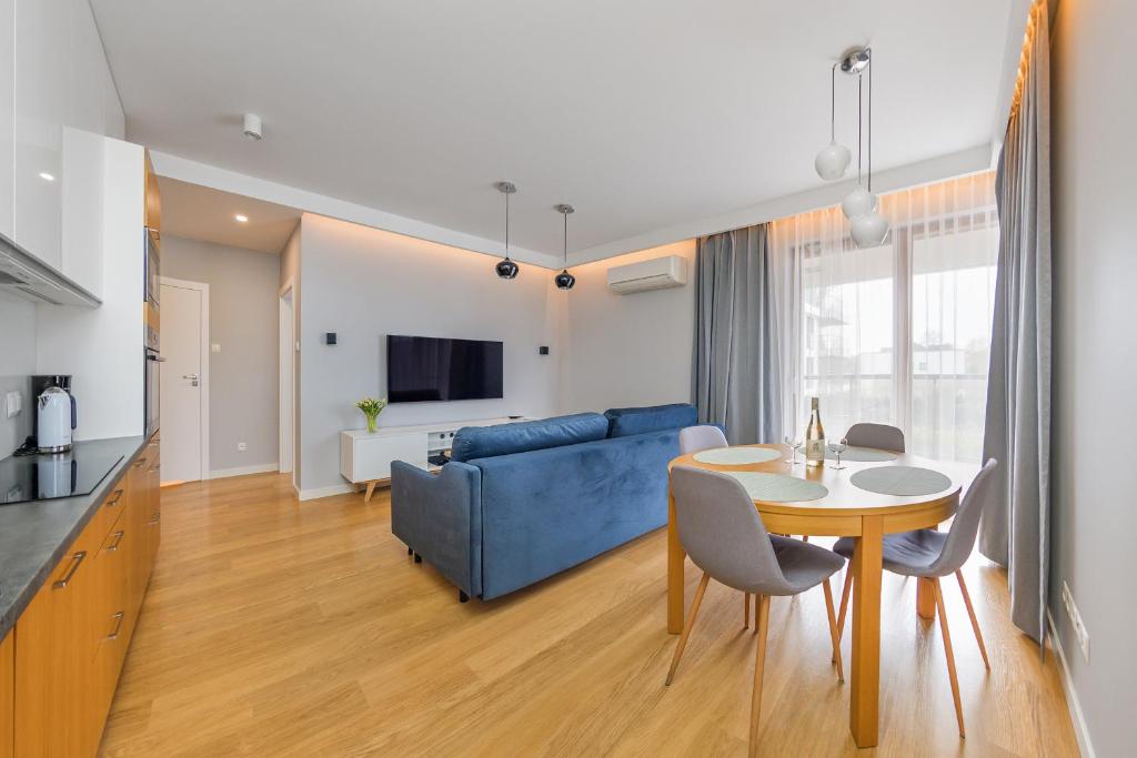 a living room with a blue couch and a table at Sunny Wood - Bursztynowa in Gdańsk