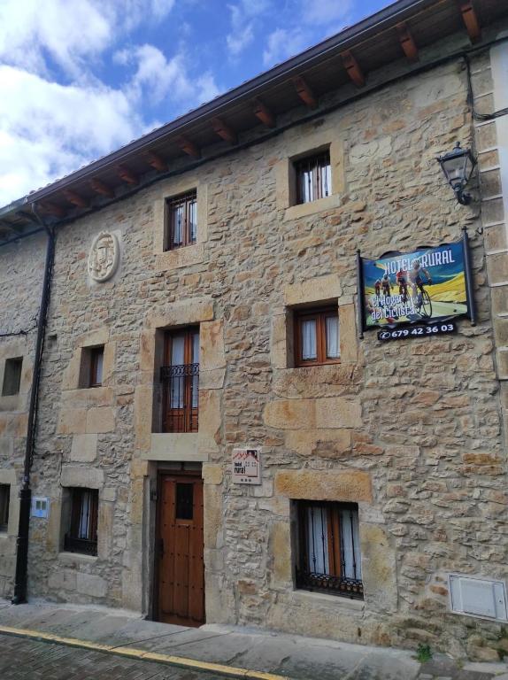 a stone building with a sign on the side of it at El Hogar del Ciclista in Espinosa de los Monteros