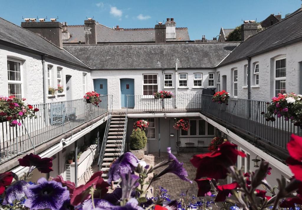 eine Reihe weißer Häuser mit Blumen vor ihnen in der Unterkunft Harbour-side, 2-bed Mews Apartment, in Torquay