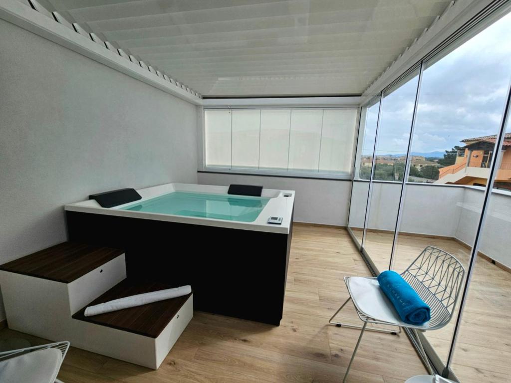 Cette chambre comprend une baignoire avec une chaise et une fenêtre. dans l'établissement Chic & Charme Luxury Rooms, à Olbia