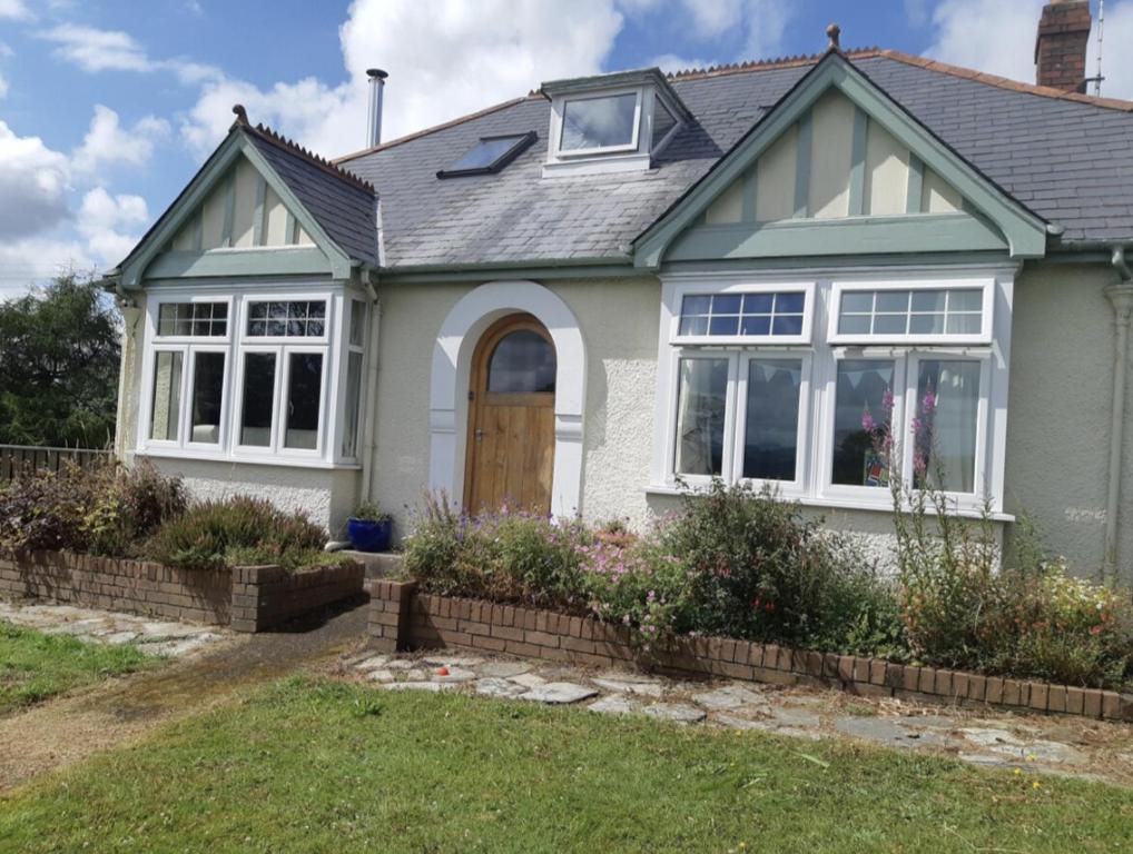 a white house with a door and windows at Brynmyrddin country living in Llandysul