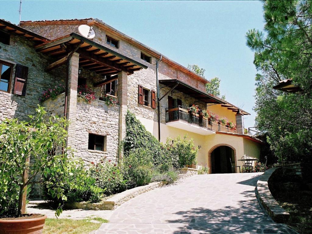 Monte Santa Maria TiberinaにあるFarmhouse in Monte s Maria Tiberina with stablesのバルコニーに花が咲く建物