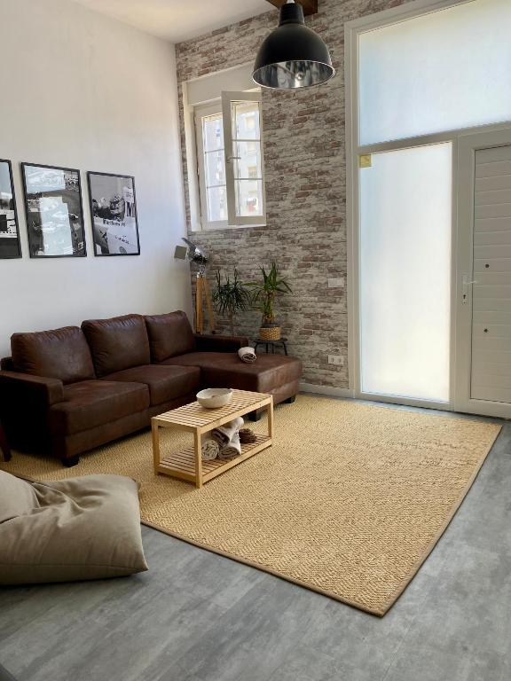 ein Wohnzimmer mit einem braunen Sofa und einem Tisch in der Unterkunft Santander industrial apartment in Santander