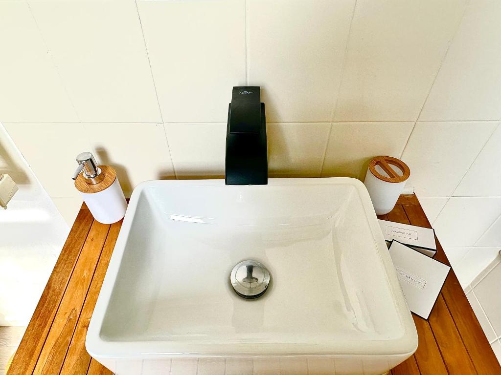 a white sink with a faucet on top of it at Duplex cosy en hypercentre de Thionville - 3min à pied de la gare in Thionville