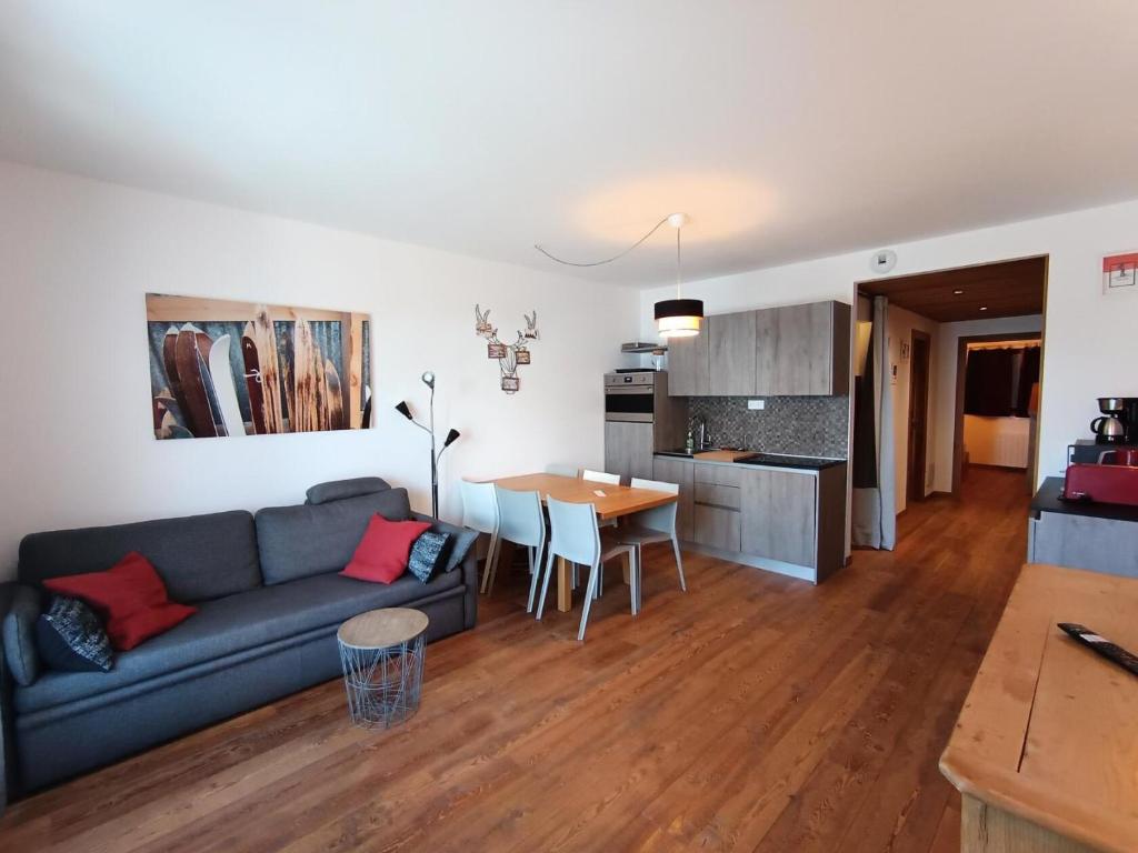 un salon et une cuisine avec un canapé et une table dans l'établissement Résidence Loup Argente - Superbe appartement luxe - Terrasse - Sud MAE-8384, à Montgenèvre