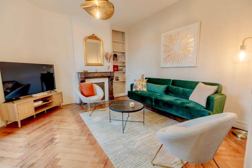 a living room with a green couch and a tv at Villa de charme La Belle Havraise 6 pers 3 chambres terrasse avec garage in Le Havre
