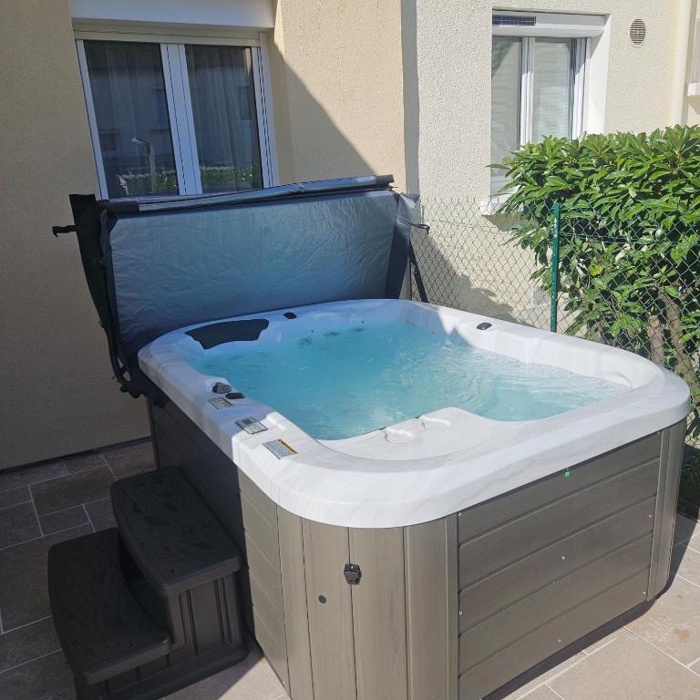 un bain à remous en face d'un bâtiment dans l'établissement Les Sorbiers & spa, à Saint-Avertin