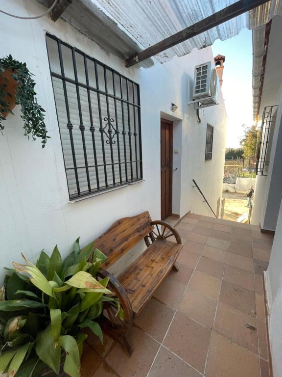 a wooden bench sitting on a patio next to a building at Zuchar in Granada