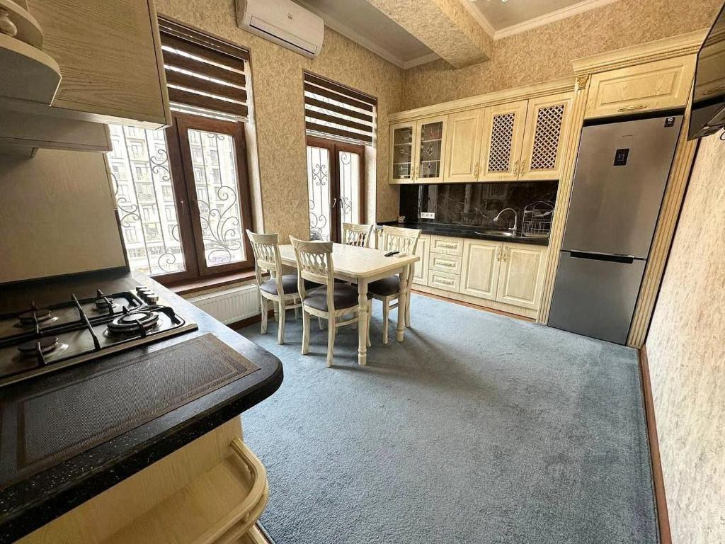 a kitchen with a table with chairs and a stove at Family House in Stantsiya Kyzyl-Tukumachi