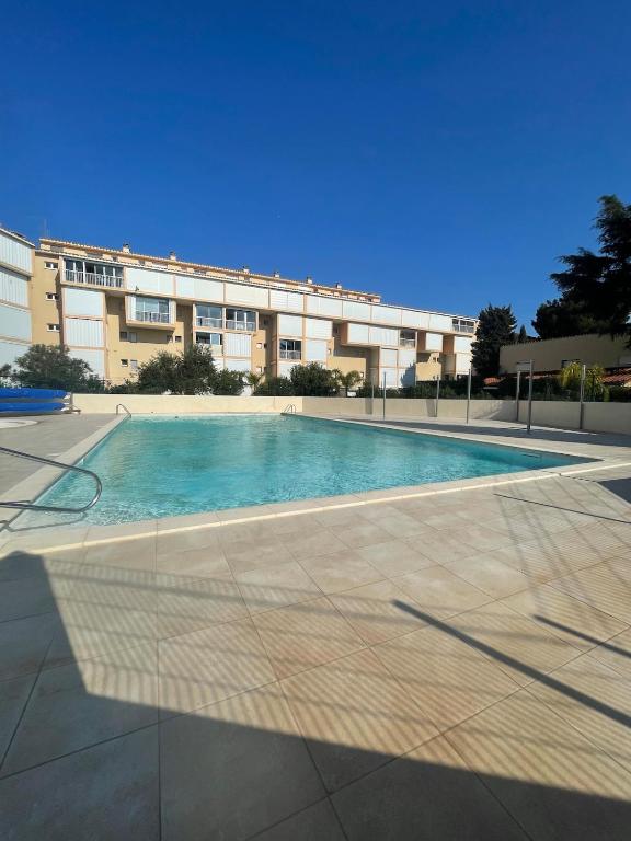 une grande piscine devant un immeuble dans l'établissement Maisonnette cosy piscine parking, à Argelès-sur-Mer