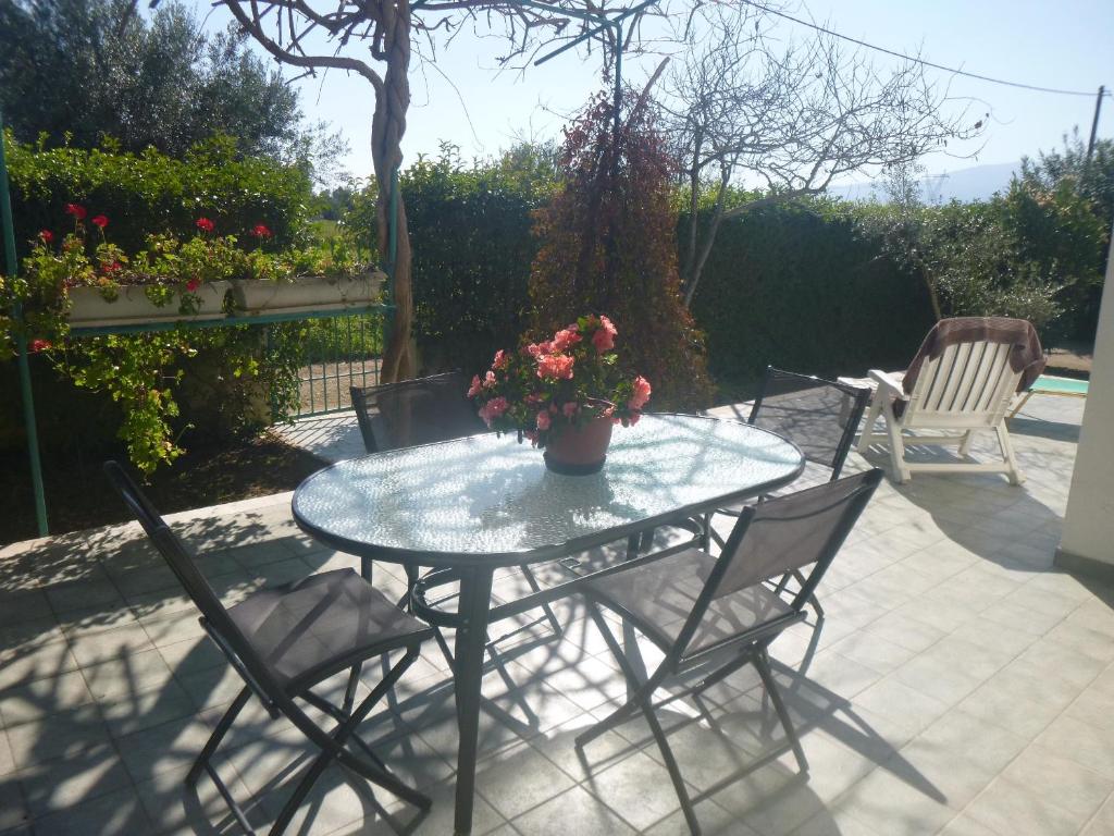a table with chairs and a potted plant on a patio at appartement lena in Messini