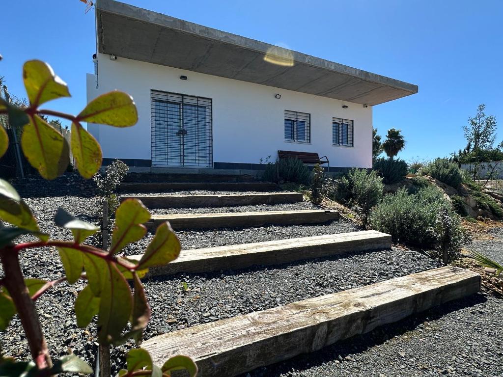 Una casa blanca con escaleras al frente. en Casa Rural Altos de María, en La Campana