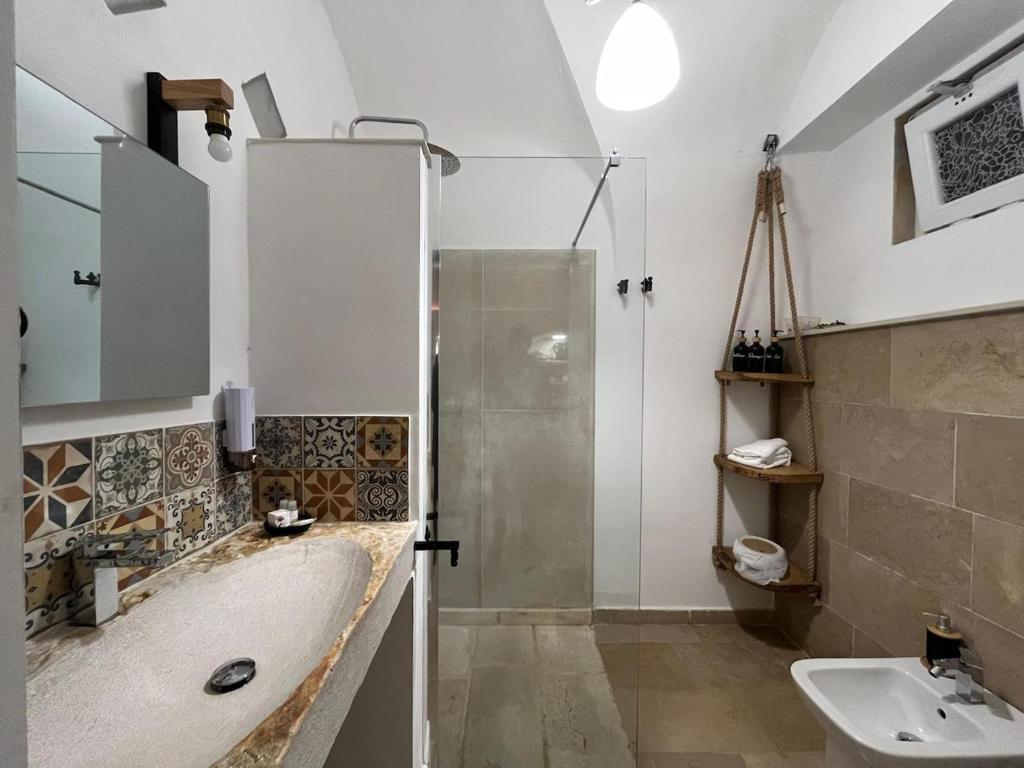 un bagno con vasca, lavandino e doccia di La suite del Marchese a Vieste a Vieste