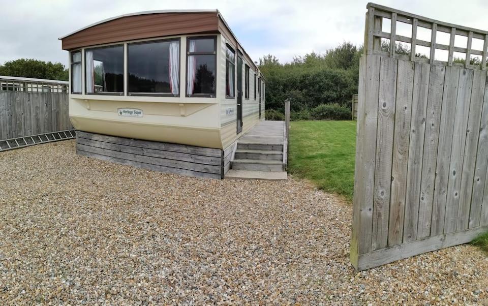 una pequeña casa con una puerta y una valla en Culver, en Newport